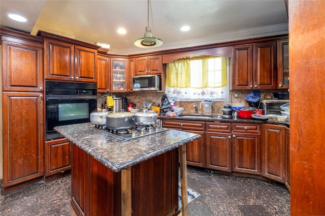 kitchen with dark stone counters, stainless steel appliances, sink, pendant lighting, and a center island