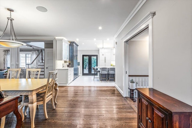 dining area with french doors, plenty of natural light, crown molding, and hardwood / wood-style floors