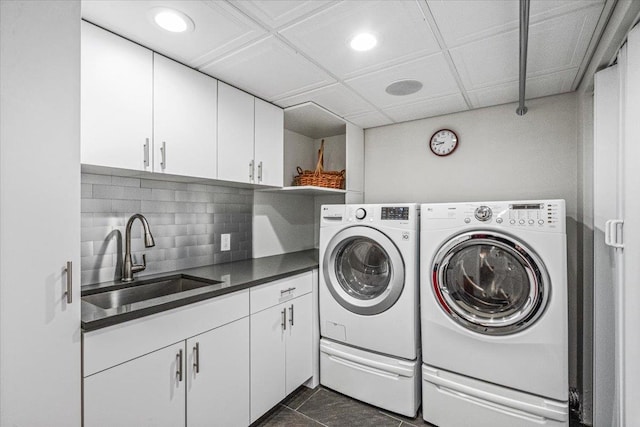 laundry room with independent washer and dryer, dark tile patterned flooring, sink, and cabinets