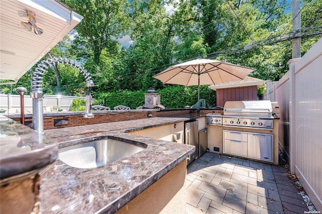 view of patio / terrace with an outdoor kitchen, area for grilling, and sink