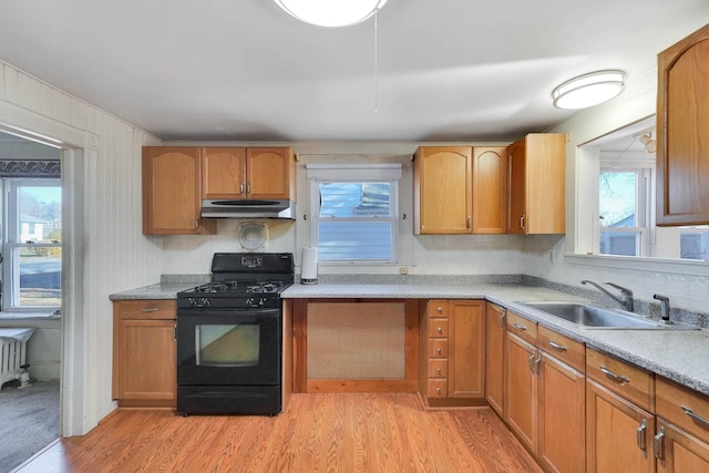 kitchen with sink, black gas stove, and light hardwood / wood-style floors