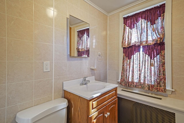 bathroom featuring radiator, tile walls, vanity, and crown molding