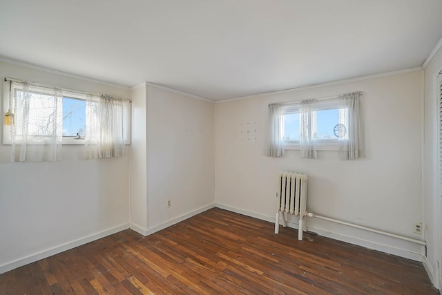 empty room with radiator, a wealth of natural light, crown molding, and dark hardwood / wood-style floors