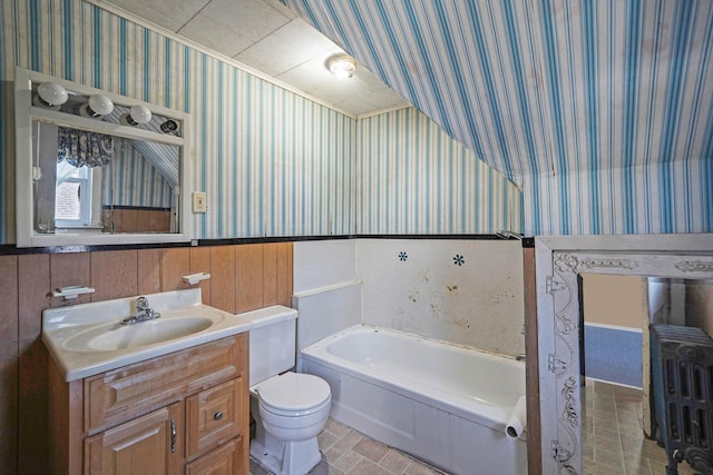 bathroom featuring a bathtub, vanity, ornamental molding, and toilet