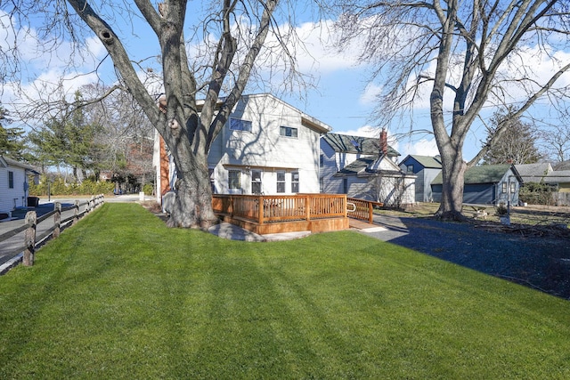 back of house with a deck and a yard