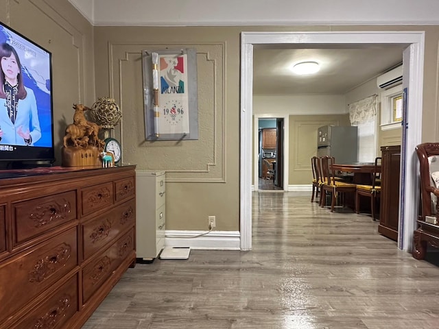 corridor featuring light hardwood / wood-style floors and a wall unit AC