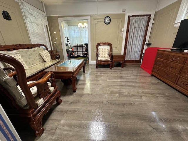 sitting room with light hardwood / wood-style flooring and an inviting chandelier