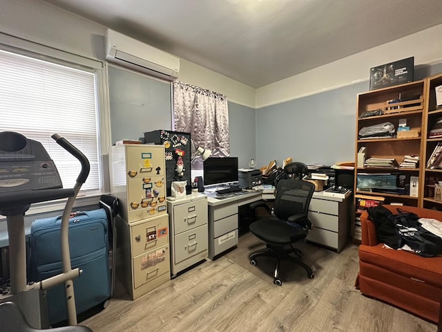 office space featuring light wood-type flooring and an AC wall unit