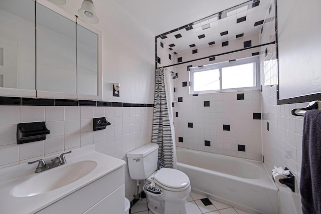 full bathroom featuring tile patterned floors, toilet, shower / tub combo with curtain, vanity, and tile walls