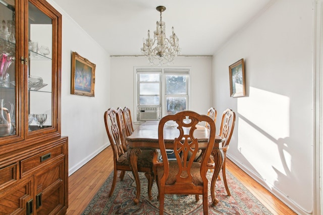 dining area featuring a notable chandelier, cooling unit, and hardwood / wood-style flooring