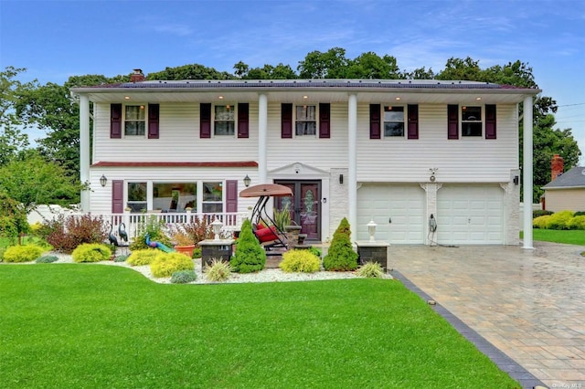 view of front facade featuring an attached garage, a chimney, a front lawn, and decorative driveway