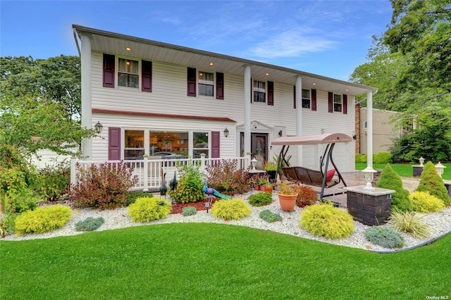 view of front of property featuring covered porch and a front yard