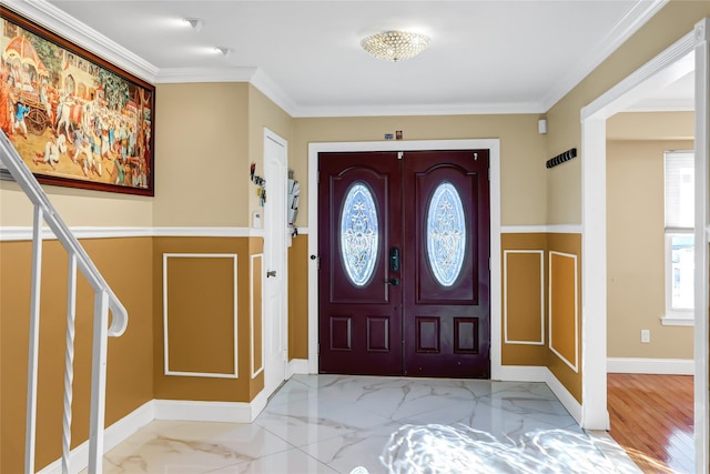 foyer with marble finish floor, crown molding, baseboards, and stairs