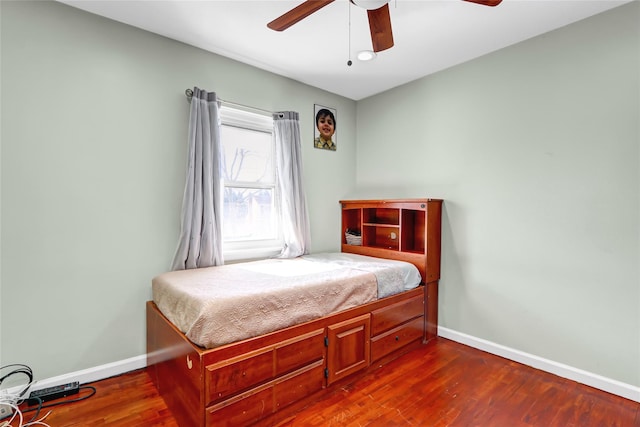 bedroom with dark wood-style floors, ceiling fan, and baseboards