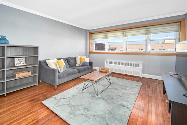 living room featuring a healthy amount of sunlight, dark hardwood / wood-style floors, radiator heating unit, and crown molding