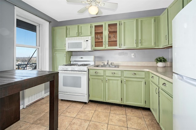 kitchen with sink, green cabinets, light tile patterned floors, ceiling fan, and white appliances