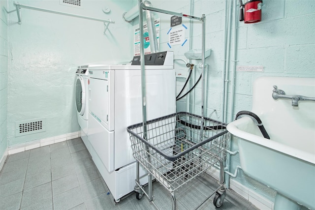 clothes washing area with sink and independent washer and dryer