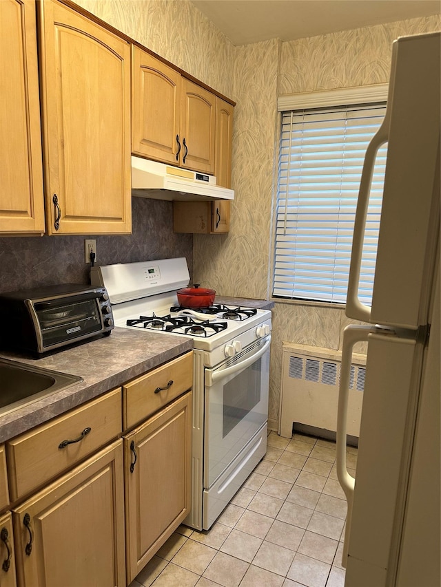 kitchen featuring sink, white appliances, radiator, and light tile patterned flooring