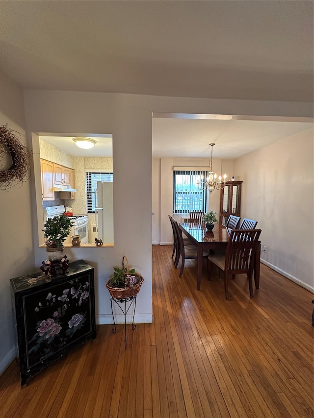 dining area featuring hardwood / wood-style flooring and an inviting chandelier