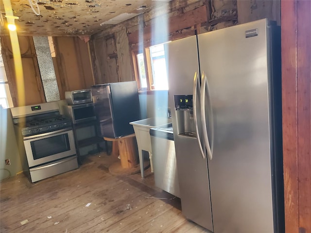 kitchen with stainless steel appliances, stainless steel counters, and light wood-type flooring