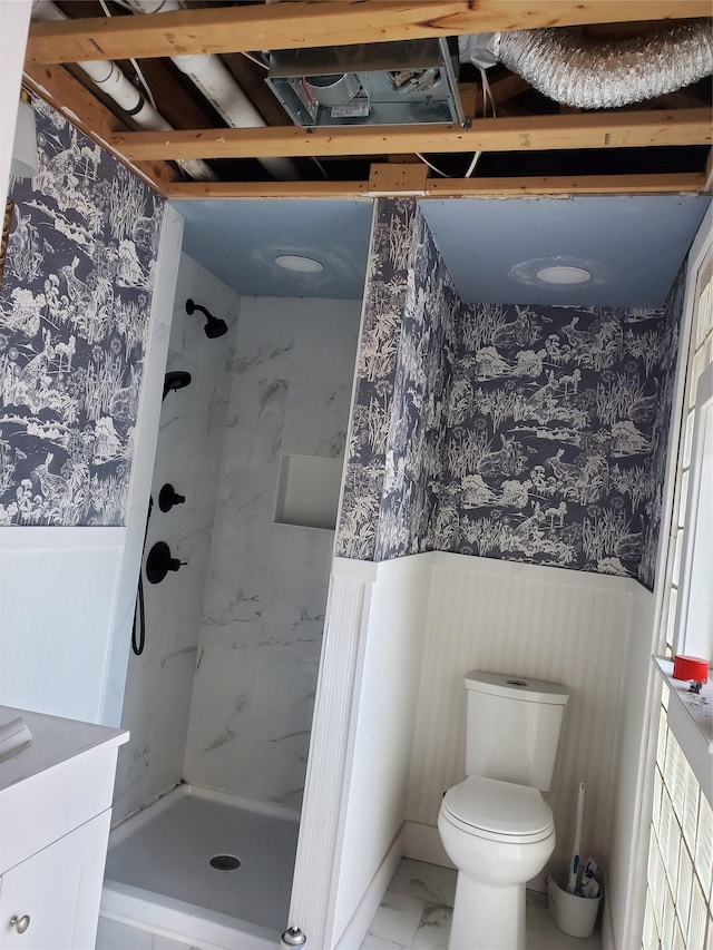 bathroom with vanity, tiled shower, and toilet