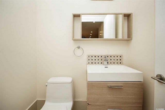 bathroom with vanity, toilet, and backsplash