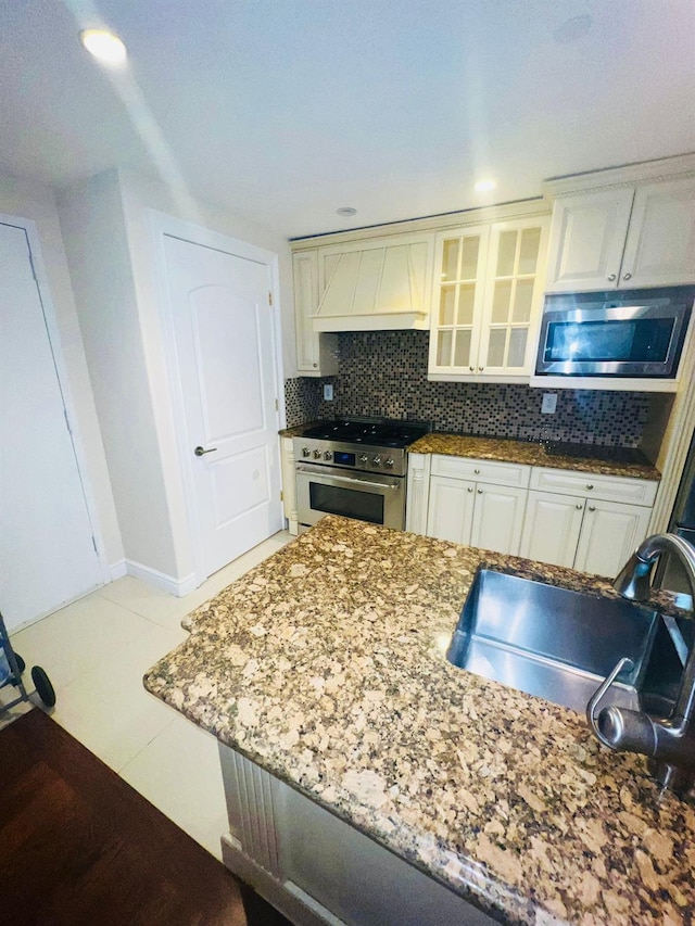 kitchen with white cabinetry, sink, stainless steel appliances, and custom exhaust hood