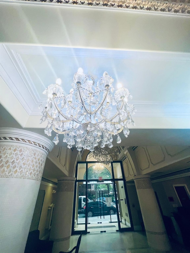 interior details with crown molding and a chandelier