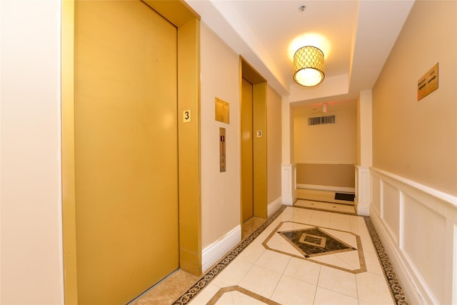 hallway featuring light tile patterned floors and elevator