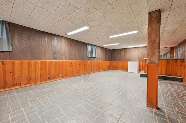 basement featuring wooden walls