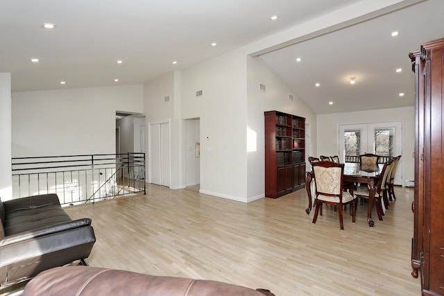 living room with high vaulted ceiling and light hardwood / wood-style floors