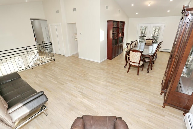 living room with a baseboard heating unit, high vaulted ceiling, and light hardwood / wood-style floors