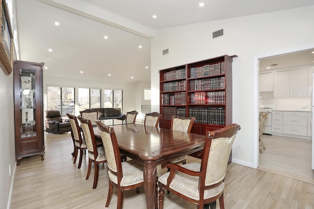 dining room featuring vaulted ceiling and light hardwood / wood-style floors