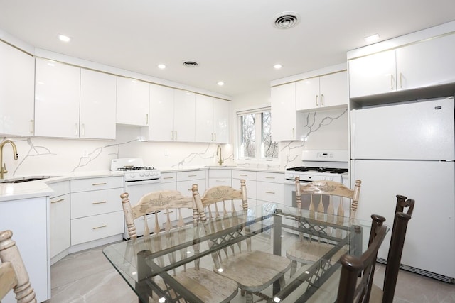 kitchen with sink, decorative backsplash, white appliances, and white cabinetry