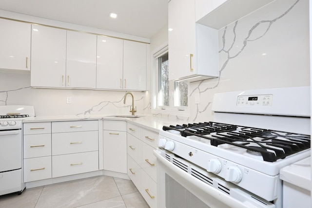 kitchen featuring white cabinets, white range with gas cooktop, decorative backsplash, and sink