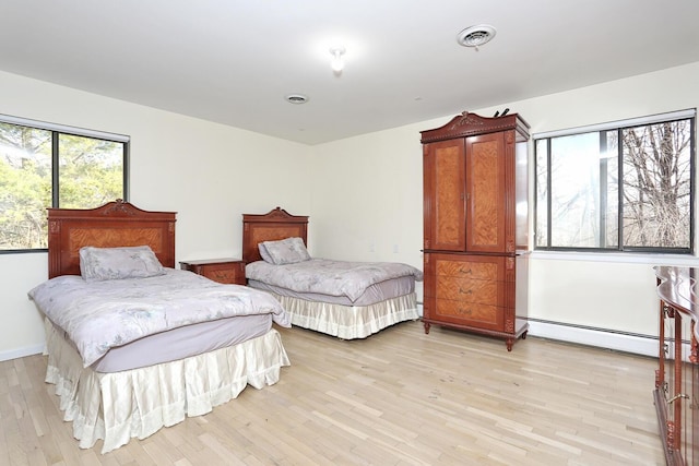 bedroom featuring baseboard heating and light wood-type flooring