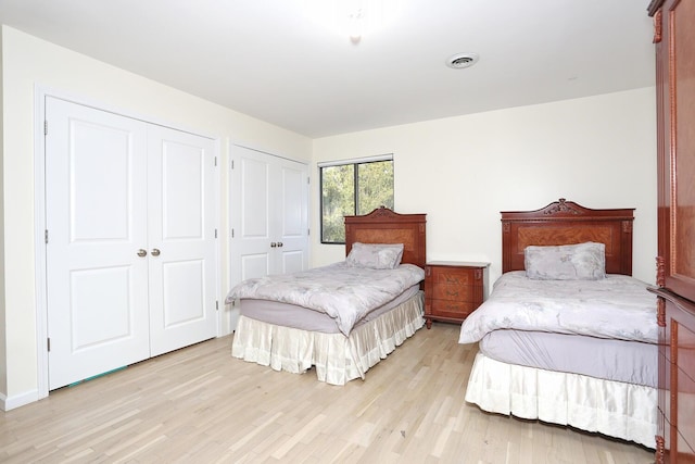 bedroom featuring multiple closets and light wood-type flooring