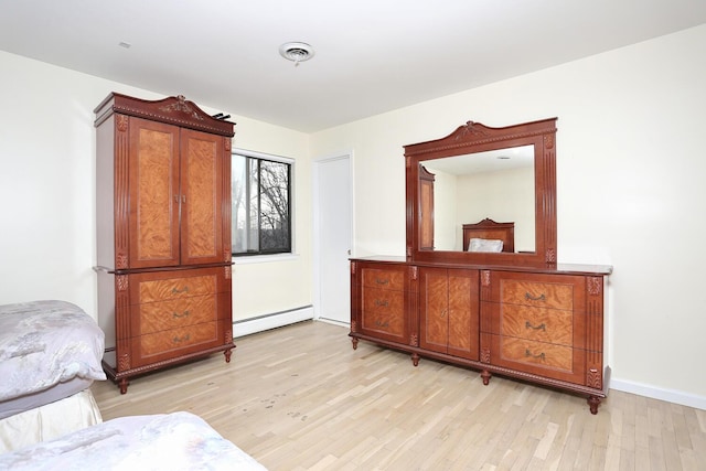 living area with baseboard heating and light hardwood / wood-style flooring