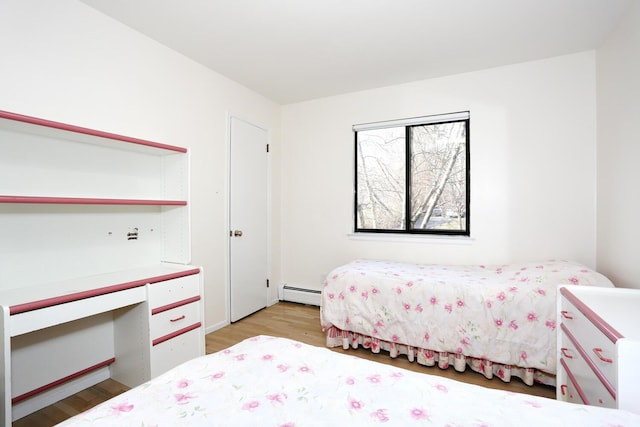 bedroom with baseboard heating and light wood-type flooring