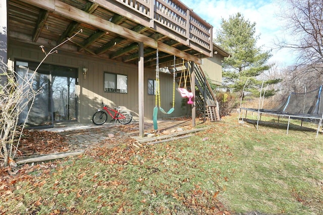 view of yard featuring a trampoline and a wooden deck