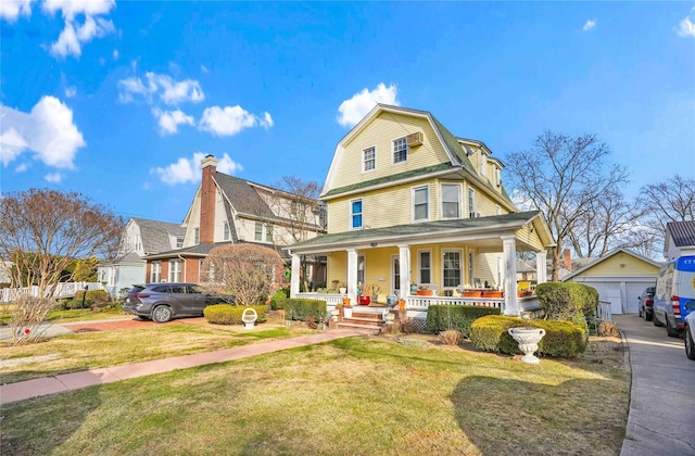 view of front of property featuring an outdoor structure, a front yard, a porch, and a garage