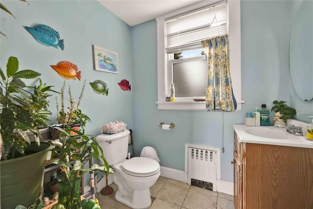 bathroom featuring tile patterned floors, vanity, toilet, and radiator