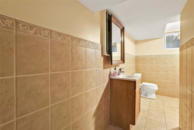 bathroom featuring tile patterned floors, vanity, tile walls, and toilet