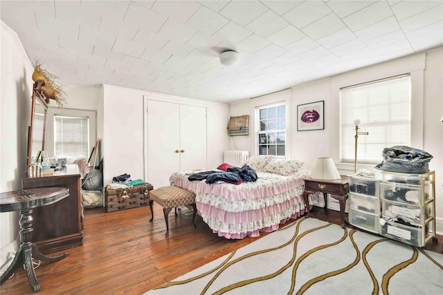 bedroom featuring hardwood / wood-style flooring and radiator