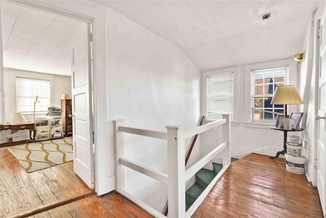 staircase with hardwood / wood-style floors and vaulted ceiling