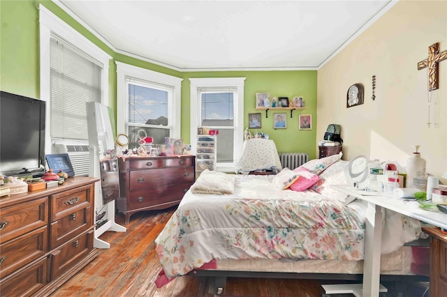 bedroom featuring radiator heating unit, ornamental molding, and dark wood-type flooring