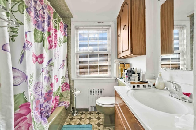 full bathroom with vanity, toilet, radiator heating unit, and shower / tub combo