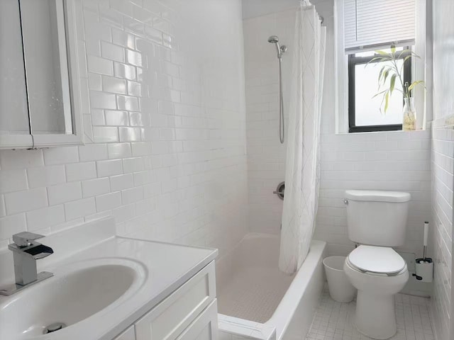 full bathroom featuring shower / bathtub combination with curtain, tile patterned floors, toilet, vanity, and tile walls