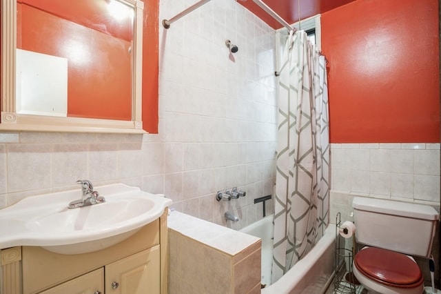 full bathroom featuring a wainscoted wall, toilet, vanity, tile walls, and shower / bathtub combination with curtain