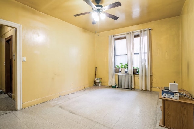 spare room with light floors, baseboards, radiator heating unit, and ceiling fan